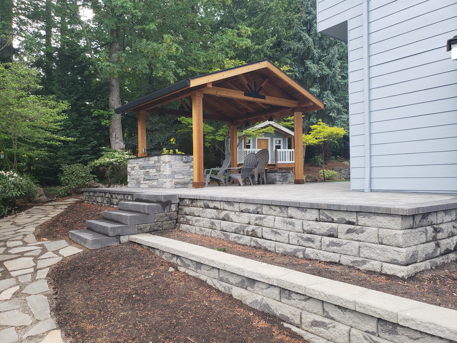 Stone blocks provide both a retaining wall and foundational support for this patio. The retaining wall has been capped with Belgard Diamond wall cap and the steps leading up to the patio are a Belgard Landings© Step unit.